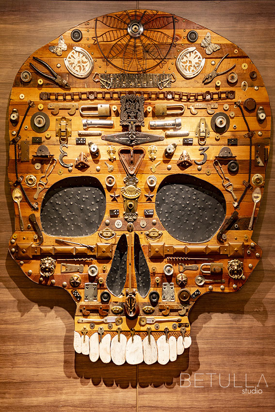 Scultura murale raffigurante un teschio realizzato con materiali industriali e di recupero, fotografata da Betulla Studio – progetto di design creativo e arte contemporanea