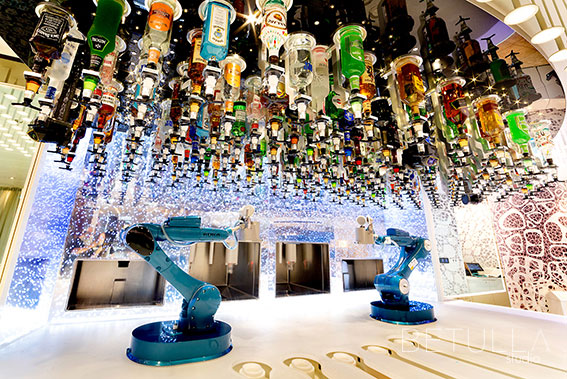 Sistema di bar robotizzato con bracci meccanici KUKA e bottiglie sospese, illuminazione LED e design futuristico – fotografia di Betulla Studio per progetti di hospitality e tecnologia